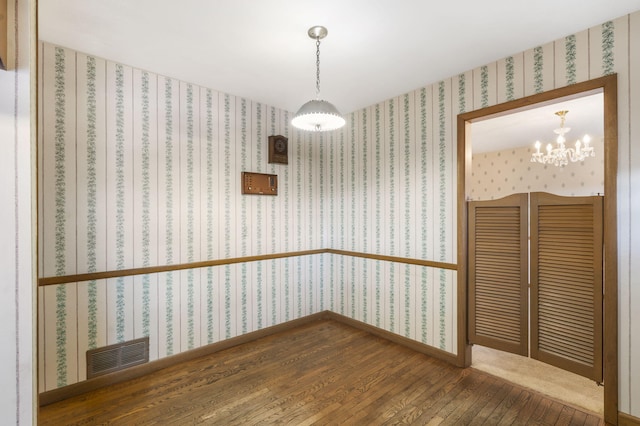 unfurnished dining area with hardwood / wood-style flooring and a chandelier