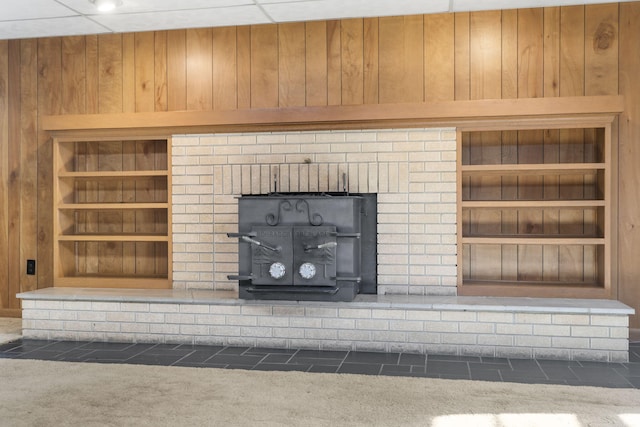 details with a fireplace, wooden walls, built in features, and carpet floors