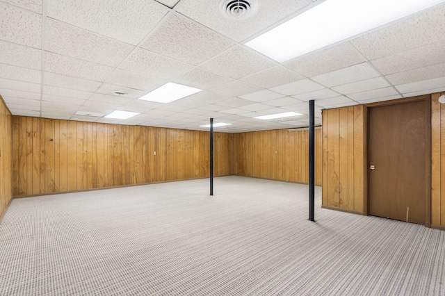 basement with a drop ceiling and light colored carpet