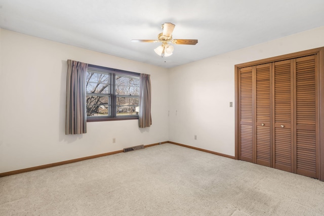 unfurnished bedroom with light carpet, a closet, and ceiling fan