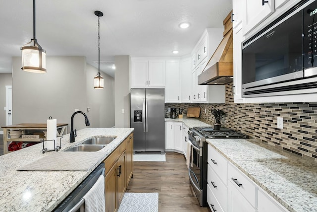 kitchen featuring white cabinets, light stone counters, hanging light fixtures, and appliances with stainless steel finishes