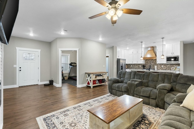 living room with ceiling fan, dark wood-type flooring, and sink