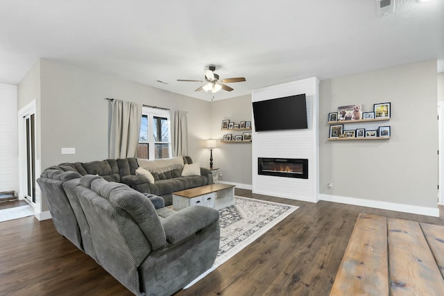 living room featuring a fireplace, dark hardwood / wood-style floors, and ceiling fan