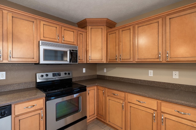 kitchen featuring light tile patterned floors, a textured ceiling, and appliances with stainless steel finishes