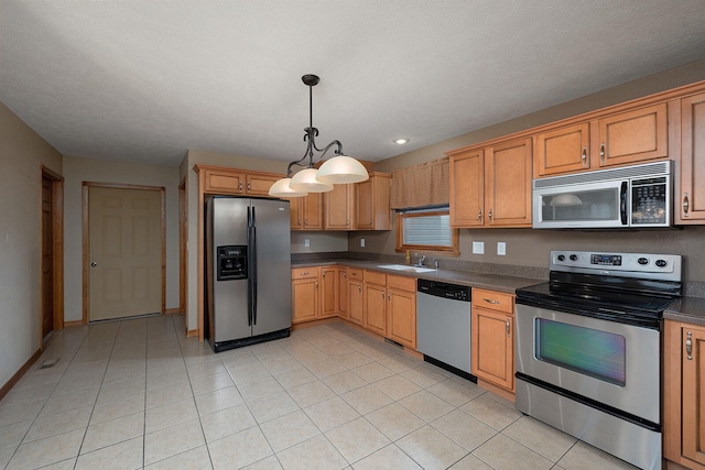 kitchen with decorative light fixtures, sink, light tile patterned floors, and stainless steel appliances