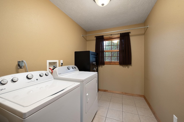 laundry room with independent washer and dryer, a textured ceiling, and light tile patterned floors