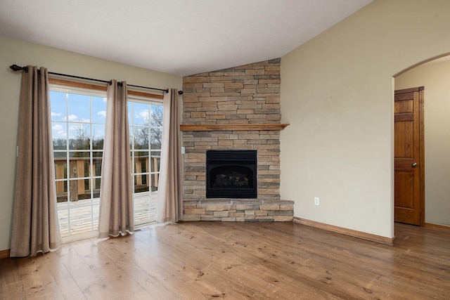 unfurnished living room with a fireplace, wood-type flooring, and vaulted ceiling