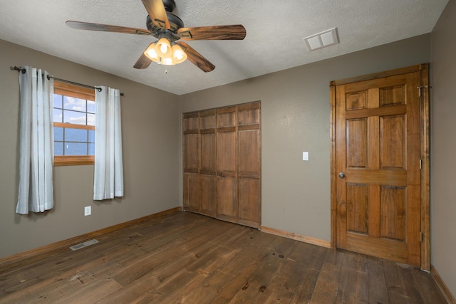 unfurnished bedroom featuring a closet, ceiling fan, and dark wood-type flooring