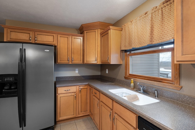 kitchen featuring sink, black dishwasher, stainless steel refrigerator with ice dispenser, a textured ceiling, and light tile patterned floors