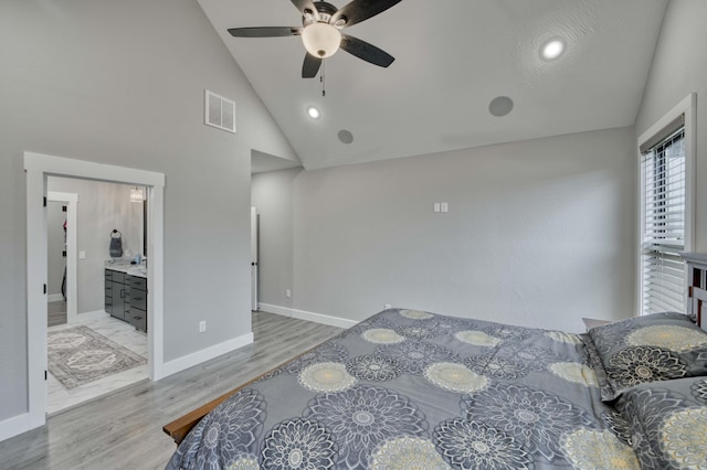 bedroom with ceiling fan, light hardwood / wood-style floors, high vaulted ceiling, and ensuite bath