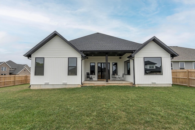 rear view of property featuring a yard and a patio