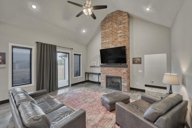 living room with a fireplace, hardwood / wood-style floors, high vaulted ceiling, and ceiling fan