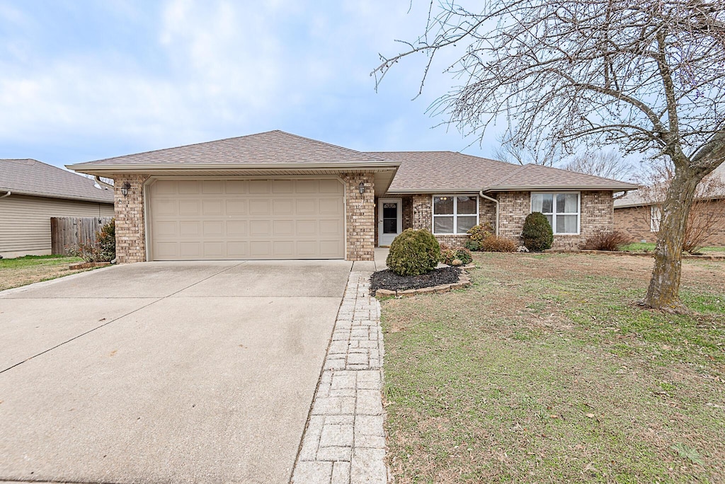 ranch-style home with a front yard and a garage