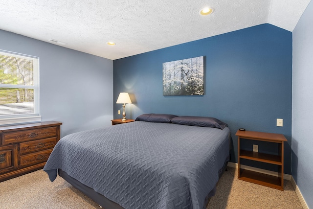 carpeted bedroom with lofted ceiling and a textured ceiling