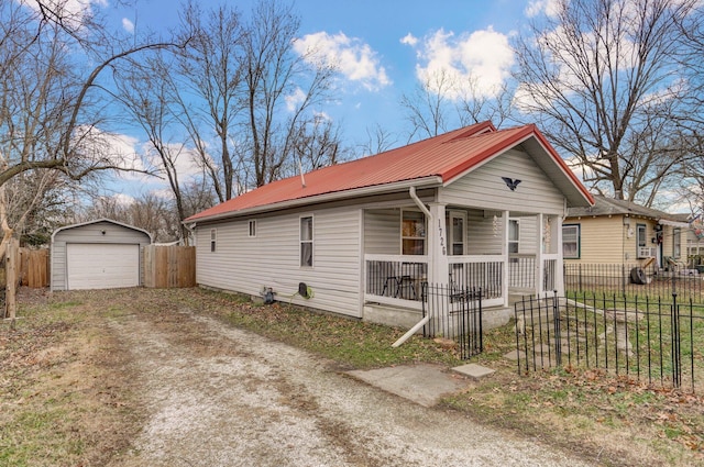 view of front of home with a garage, covered porch, and an outdoor structure