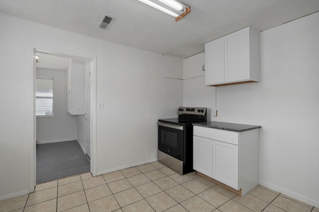 kitchen with white cabinetry, electric range, and a textured ceiling