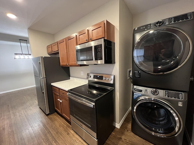 kitchen featuring dark hardwood / wood-style floors, stacked washer / dryer, and stainless steel appliances