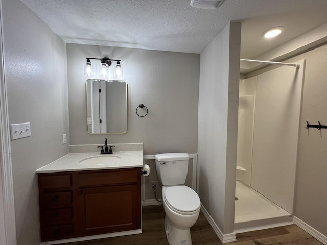 bathroom with a shower, a textured ceiling, hardwood / wood-style flooring, and toilet