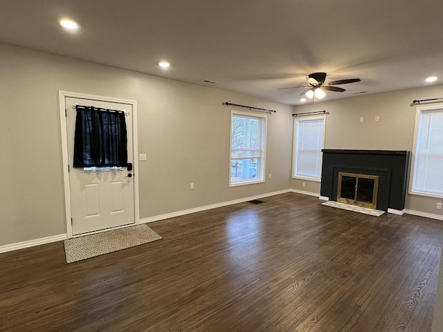 unfurnished living room featuring ceiling fan and dark hardwood / wood-style flooring