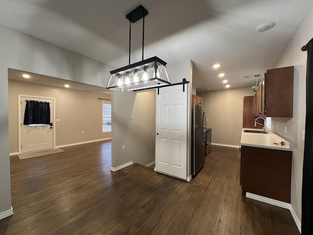 unfurnished dining area featuring a barn door, dark hardwood / wood-style flooring, and sink