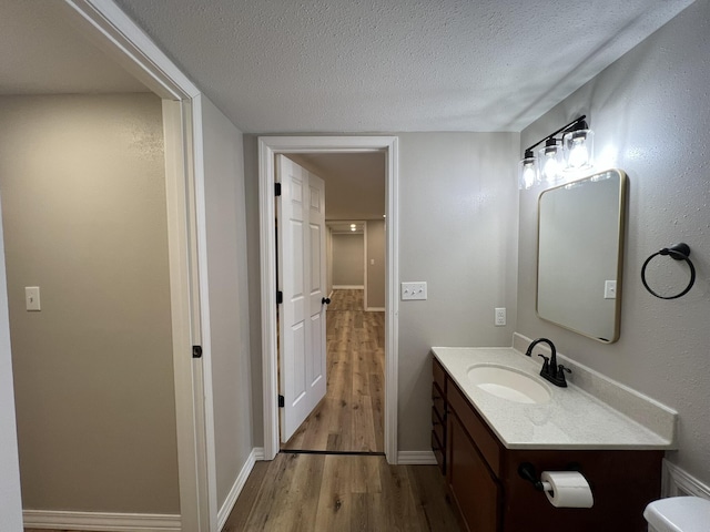 bathroom featuring hardwood / wood-style floors, vanity, a textured ceiling, and toilet