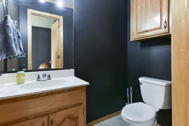 bathroom with toilet, vanity, and tile patterned floors