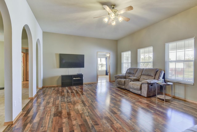 living room featuring ceiling fan and dark hardwood / wood-style flooring