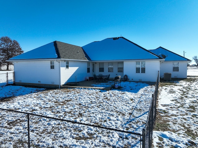 snow covered back of property featuring central air condition unit