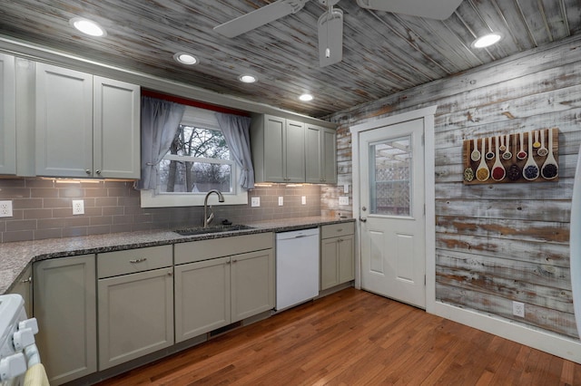 kitchen with stone counters, dishwasher, sink, tasteful backsplash, and light wood-type flooring