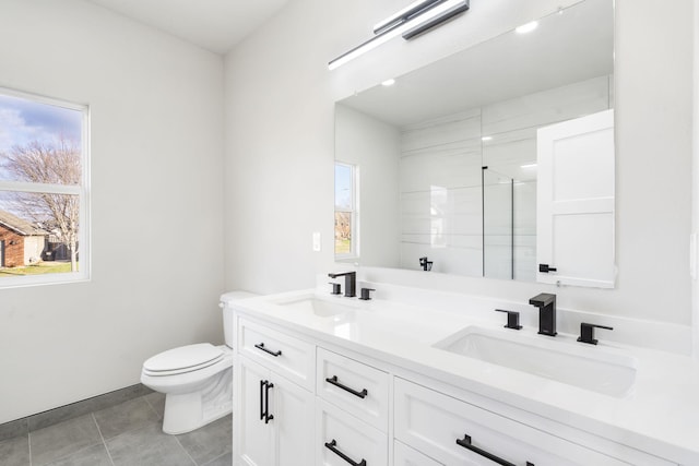 bathroom with tile patterned flooring, vanity, a shower with shower door, and toilet