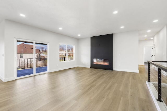 unfurnished living room featuring light wood-type flooring and a fireplace