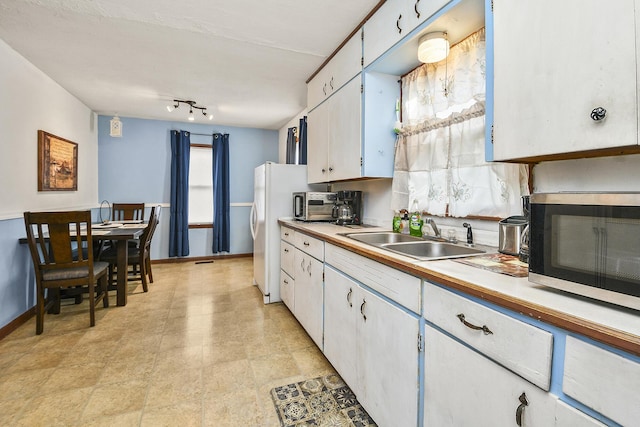 kitchen featuring white cabinetry, sink, and white refrigerator