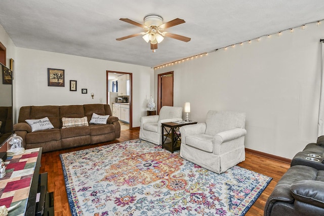 living room featuring ceiling fan, a textured ceiling, and hardwood / wood-style flooring