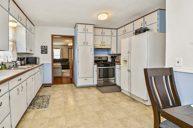 kitchen with white cabinets, gas stove, white fridge with ice dispenser, and sink