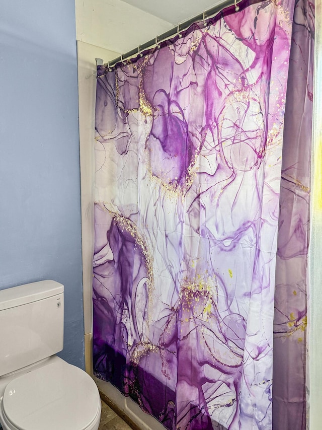 bathroom featuring toilet and shower / bath combo with shower curtain