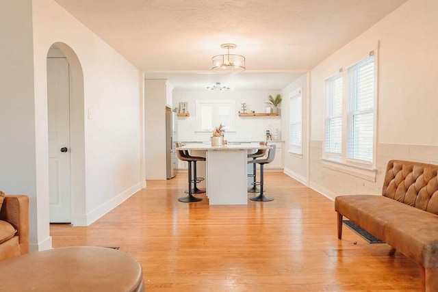 living area with light hardwood / wood-style floors and an inviting chandelier