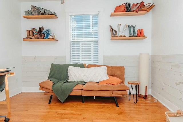 sitting room featuring wood-type flooring and wood walls