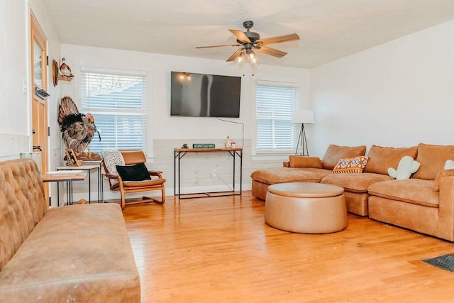 living room with hardwood / wood-style flooring, ceiling fan, and a wealth of natural light