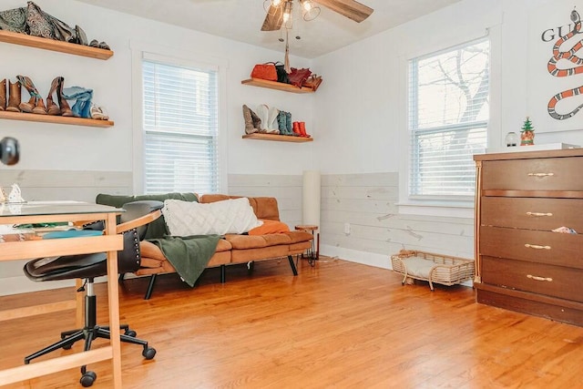 office with hardwood / wood-style flooring, ceiling fan, and wooden walls