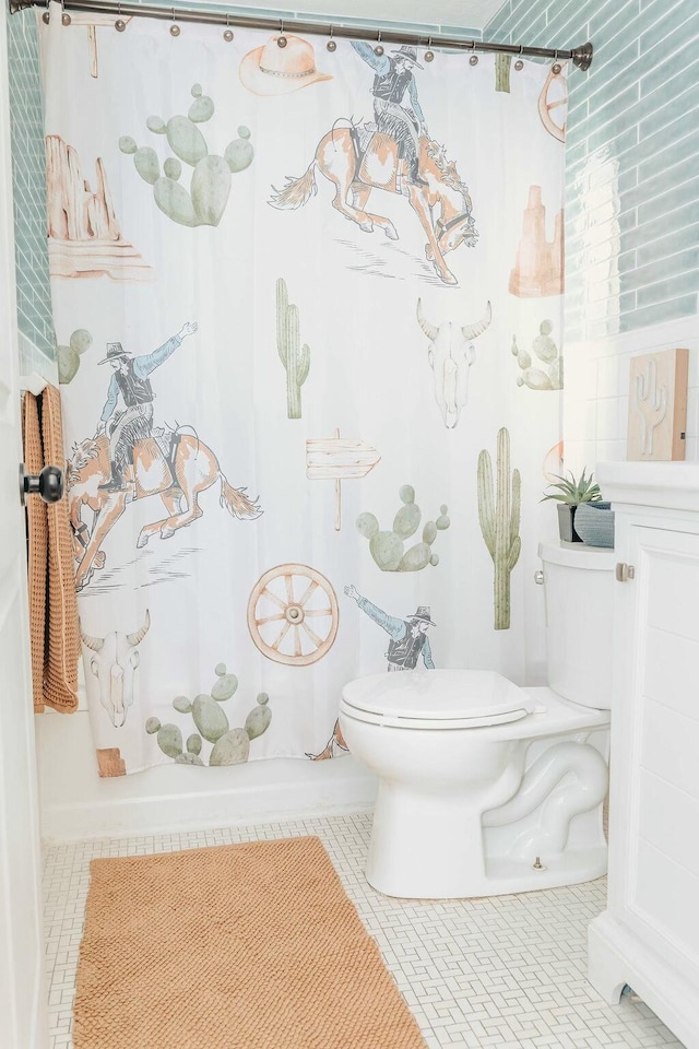 bathroom featuring tile patterned flooring, shower / bath combination with curtain, and toilet