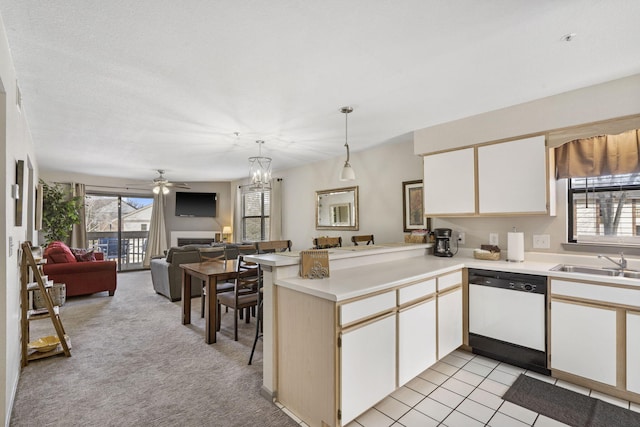 kitchen featuring dishwasher, sink, kitchen peninsula, light colored carpet, and white cabinets