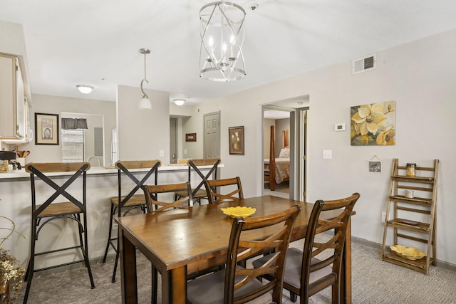 dining room with carpet and a chandelier