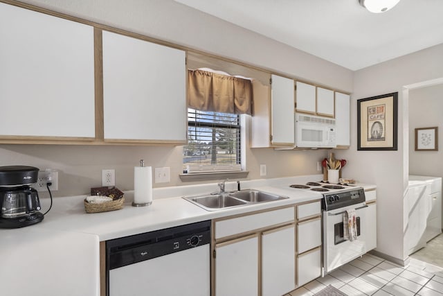 kitchen with white appliances, white cabinets, sink, washing machine and dryer, and light tile patterned floors