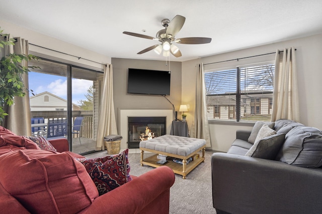 living room featuring carpet flooring, ceiling fan, and a healthy amount of sunlight