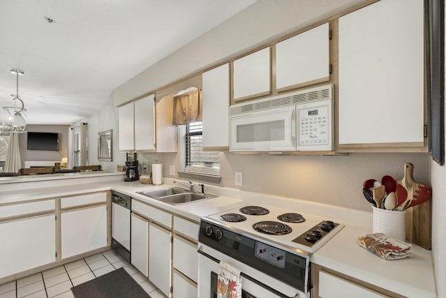 kitchen with white appliances, sink, a chandelier, white cabinetry, and light tile patterned flooring