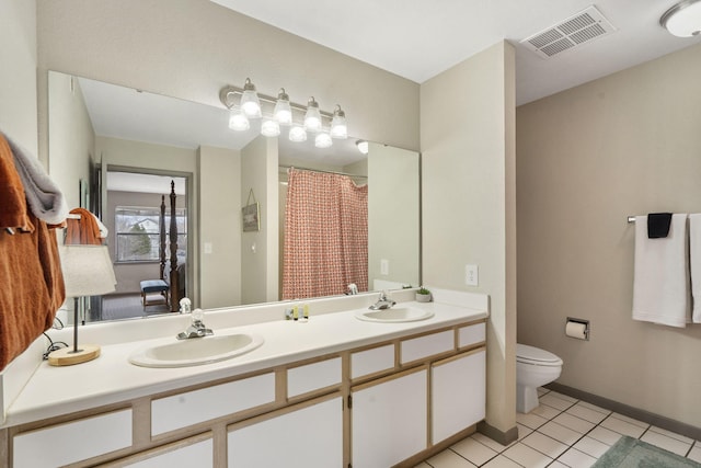 bathroom featuring tile patterned flooring, vanity, and toilet