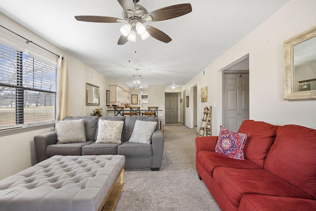 living room featuring light carpet and ceiling fan with notable chandelier