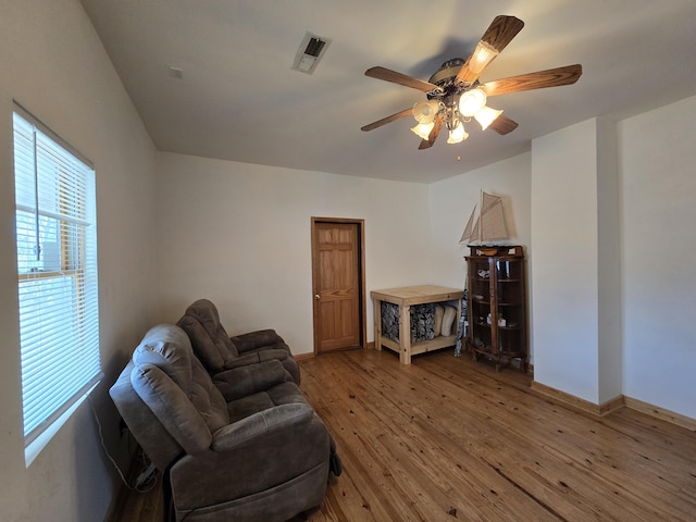 sitting room with ceiling fan and wood-type flooring