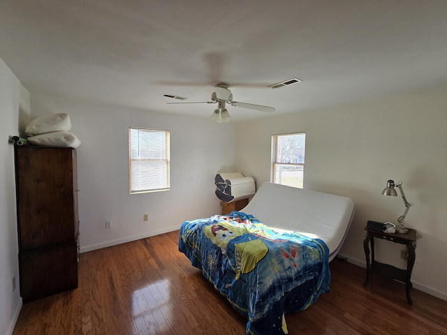 bedroom with dark hardwood / wood-style flooring and ceiling fan