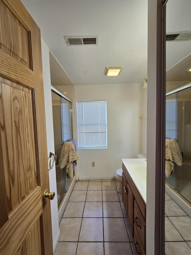 bathroom with tile patterned flooring, vanity, toilet, and an enclosed shower